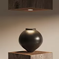 Black Ceramic Vessel Displayed On Wooden Base With Overhead Light In Minimalist Design