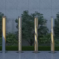 Illuminated Outdoor Lights with Spiral Column Design Against Gray Wall and Green Trees
