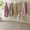 Soft Colored Hanging And Rolled Towels In White Wall Containers With Green Plant