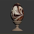 Decorated Chocolate Egg With Red And White Marble Pattern And Gold Sprinkles On Wooden Stand