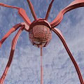 Red Sculpture With Long Curved Legs And Mesh Sphere Against Blue Sky