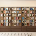 Wooden Bookshelf Filled With Various Colorful Book Spines And Art Prints