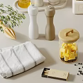Spice Bottles and Pepper Grinders with Cheese Jar Herbs and Towel on Kitchen Countertop