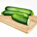 Fresh Green Zucchini on Wooden Cutting Board with Sliced Half