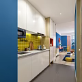 Vibrant Blue Wall Apartment Living Room With Sofa Coffee Table Yellow Stool And Wall Art