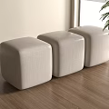 Three Beige Square Fabric Stools On Wooden Floor Near Window With Green Plant