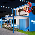 Scenic Outdoor Event Space With Triangular Tent Wooden Deck Tables Chairs Umbrellas And Grassy Area