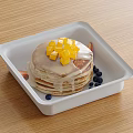 Stack of Fluffy Pancakes in White Container Topped with Mango Chunks Syrup and Blueberries