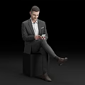 Man in Suit Sitting on Black Cube Holding and Looking at Phone