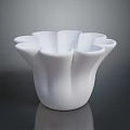 Fresh Green Plants In White Petal Shaped Vase On Dark Reflective Surface
