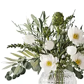 White Flowers in Transparent Textured Glass Vase with Green Leaves and Foliage
