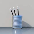 Silver Striped Metal Pen Holder With Black Pens White Tips On Gray Desktop