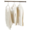 Three White Clothes Hanging On Metal Hanger For Fashion Wardrobe Styling