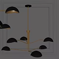 Modern Chandelier With Golden Branches And Hemispherical Black Shades Against Dark Wall