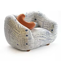 Single Sofa Featuring Blue and White Geometric Pattern with Orange Cushion and Wooden Legs