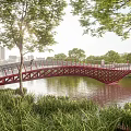 Red Arch Bridge Over Water With Greenery Trees And People Walking