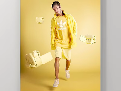 Man in yellow Adidas hoodie and shorts against yellow background with floating camera and bag 3d model