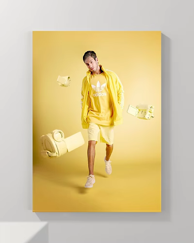 Man in yellow Adidas hoodie and shorts against yellow background with floating camera and bag 3d model