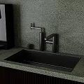 Black Kitchen Sink On Green Speckled Countertop With Modern Faucet And Fresh Fruits