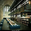 Cultural Center Interior With Arched Structure Stone Columns Bookshelves And Reading Tables Full Of Books