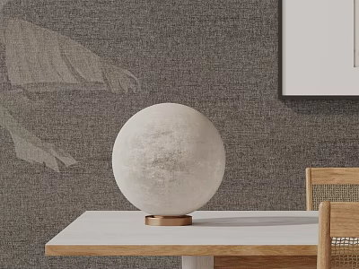 Round Lunar-Textured Table Lamp with Brass Base on Light Wooden Table against Gray Textured Wall 3d model