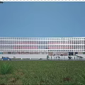 Modern Library Building With Striped Glass Facade Green Lawn Trees Front Entrance And Illuminated Exterior