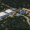 Aerial View of Industrial Factory Surrounded by Lush Forests River and Mountain Backdrop