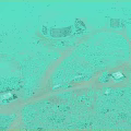 Desert Industrial Facility Aerial View With Two Large Cylindrical Tanks Vehicles Small Buildings and Vegetation