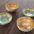 Handcrafted Ceramic Dinnerware Set with Four Colorful Bowls and Spiral Patterns on Wooden Tabletop