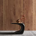 Black Curved Side Table with Ceramic Vase and Red Flowers Against Wooden Wall Background