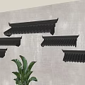 Multiple Black Roof Tile Shaped Wall Decor Arranged On Gray Wall With Green Plant