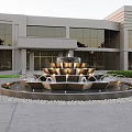 Multi Tiered Water Fountain In Front Of Modern Building With Glass Windows And Green Shrubs
