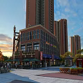 Vibrant Commercial Street At Sunset With High Rise Buildings Pedestrians Shops And Greenery