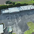Spacious Commercial Parking Lot With Parked Cars And Green Surrounding Trees
