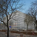 Modern Office Building With Glass Facade Surrounded By Trees On City Street And Parked Cars