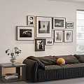 Stylish Photo Wall with Framed Black and White Pictures Above Dark Sofa and Green Plant