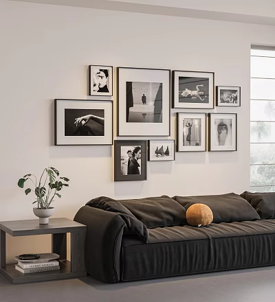 Stylish Photo Wall with Framed Black and White Pictures Above Dark Sofa and Green Plant 3d model