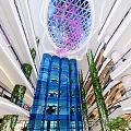 Modern Mall Interior With Glass Dome Purple Flowers Blue Glass Walls And Green Plants