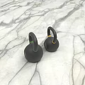 Two Black Kettlebells With Green And Yellow Rings For Fitness On Marble Surface