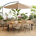 Outdoor Table with Rattan Chairs and Beige Umbrella Surrounded by Green Plants and Flowers