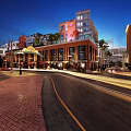 Vibrant Commercial Street At Night With Modern Buildings And Outdoor Dining Areas