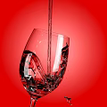Wine Bottle And Glass On Red Background Showing Liquid Pouring Bubbles And Splashes