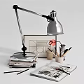 Modern Desk Lamp With Stack Of Books Stationery And Drawing On Workspace