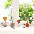 Colorful Hourglass Decorative Ornament Set On Window Sill With Green Plants Background