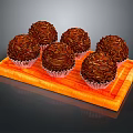Delicious Chocolate Truffles Arranged On Orange Wooden Board With White Wrappers