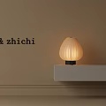 Striped Table Lamp On White Shelf Against Beige Wall With Warm Yellow Light
