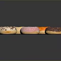 Colorful Donuts With Various Frosting And Sprinkles On Black Sleek Surface