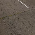 Damaged Road Infrastructure With Cracks And White Lane Line On Asphalt Surface