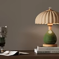 Green Table Lamp With Pleated Beige Lampshade On Stacked Books And Decorative Doll