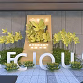 Floral Art Installation With Yellow Flowers Green Plants And White Letter Decorations For Real Estate